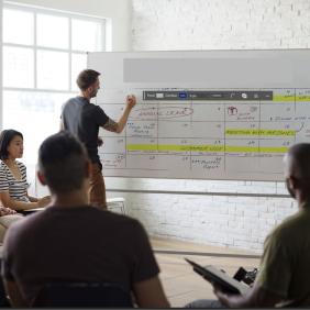 Un formateur annote des éléments sur un tableau face à des élèves