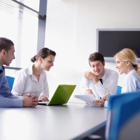 Réunion entre 4 collègues autour d'une grande table