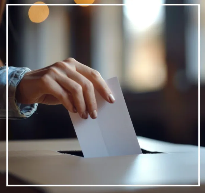 Photographie d'une main glissant un bulletin dans une urne