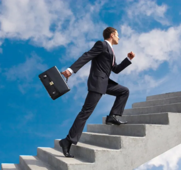 Homme en costume et attaché-case gravissant un escalier
