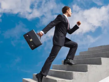 Homme en costume et attaché-case gravissant un escalier