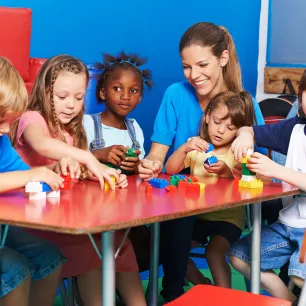 Photo d'illustration d'une ATSEM entourée d'enfants