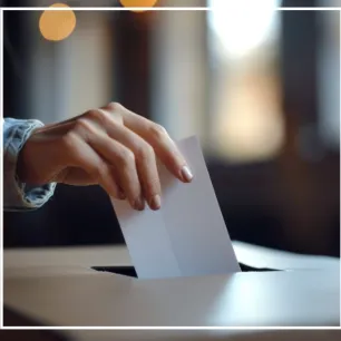 Photographie d'une main glissant un bulletin dans une urne