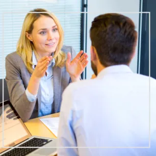 Photographie de deux personnes échangeant autour d'un bureau