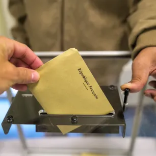 Main glissant un bulletin dans l'urne