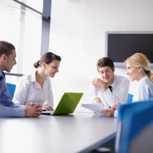 Réunion entre 4 collègues autour d'une grande table